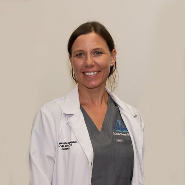smiling female veterinarian wearing white lab coat